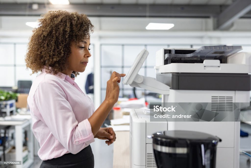 Business woman working at the office and copying a document African American business woman working at the office and copying a document Photocopier Stock Photo
