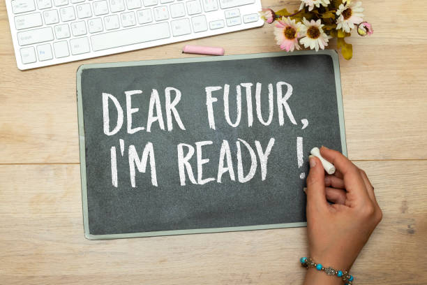 istock woman hand holding a chalk and writing Dear Future, I'm Ready on chalkboard, desktop. technology, internet concept 1471700745