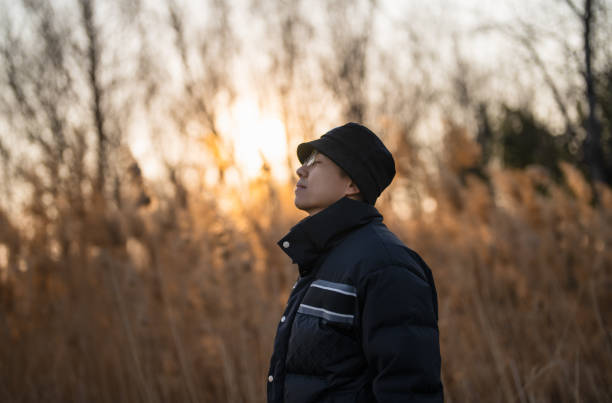 istock Chinese man standing in the forest and making a fascinated expression at sunset 1471703159