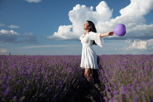 Playful young woman wandering in a lavender filed.