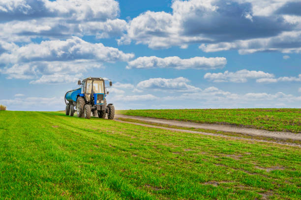 istock An agricultural tractor drives along a field road. Spring Field 1471703519