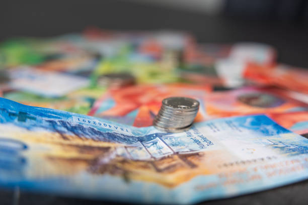 istock Swiss coins lie on Swiss banknotes with a soft bokeh. 1471708587