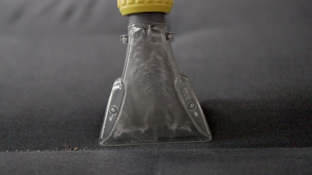 Dirty water bubbling in the nozzle of washing vacuum close-up. Slow motion video.