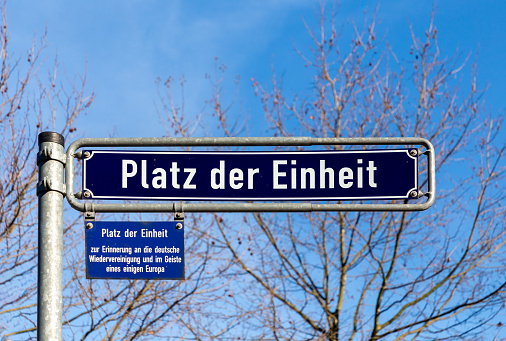 old enamel street name sign Platz der Einheit - engl:  German unity to remember in sence of Europe - in Frankfurt, Germany under blue sky