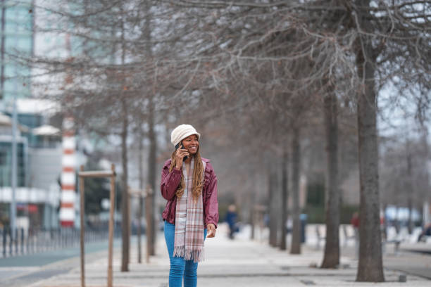 istock Woman walking talking on cell phone 1471710200
