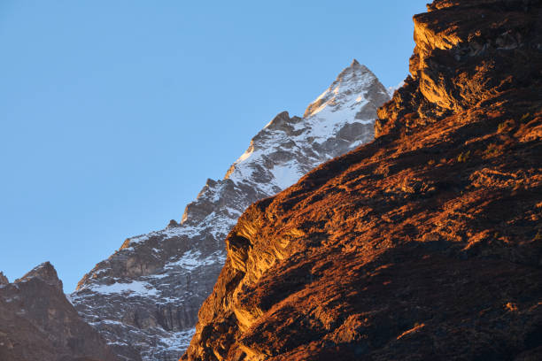 alpenglow rocky cliffs and a snowy mountain peak - alpenglow imagens e fotografias de stock