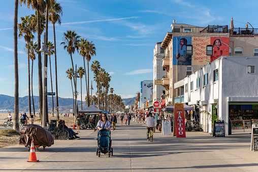 Los Angeles, United States - November 17, 2022: A picture of the iconic Venice Beach boardwalk with people walking on it.