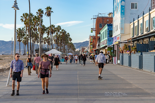 Los Angeles, United States - November 17, 2022: A picture of the iconic Venice Beach boardwalk with people walking on it.