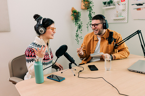 Two Young Stylish Radio Show Hosts Record Fresh Podcast Episode in Home Loft Studio Apartment. Attractive Energetic Co-hosts Discuss Important Topics Live on Air in an Show