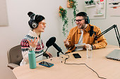 Two Young Stylish Radio Show Hosts Record Fresh Podcast Episode in Home Loft Studio Apartment. Attractive Energetic Co-hosts Discuss Important Topics Live on Air in an Show