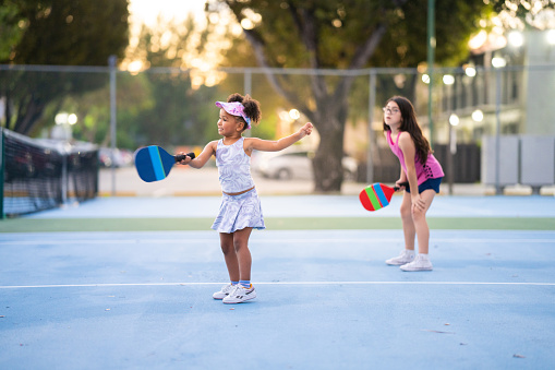Girls playing pickle ball outdoors