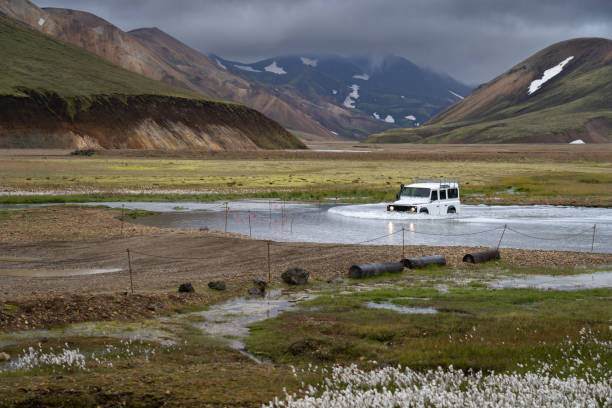 4WD car crossing a river near Landmannalaugar campsite in Icelandic highlands 4WD car crossing a river near Landmannalaugar campsite in Icelandic highlands ford crossing stock pictures, royalty-free photos & images