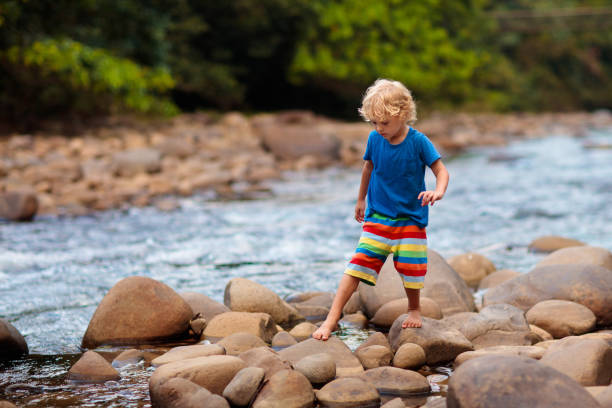 istock Child hiking in mountains. Kids at river shore. 1471719630