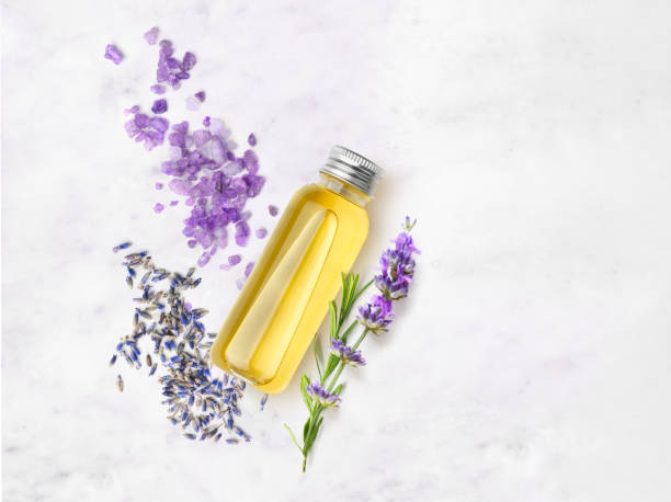 olio essenziale e sale di lavanda con fiori su un tavolo di marmo - lavender lavender coloured flower herb foto e immagini stock