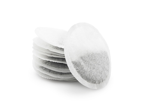 Round black tea bags isolated on white background