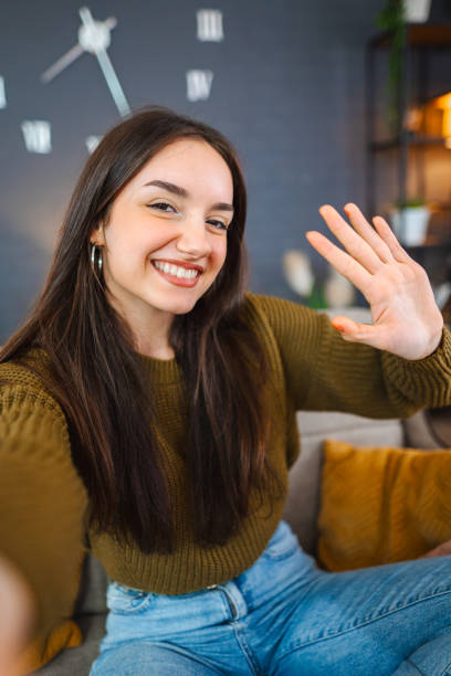 istock Smiling young woman taking selfies while relaxing at home 1471725737