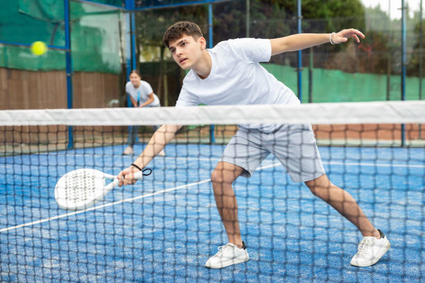 istock Sporty young guy playing padel on open court 1471725780