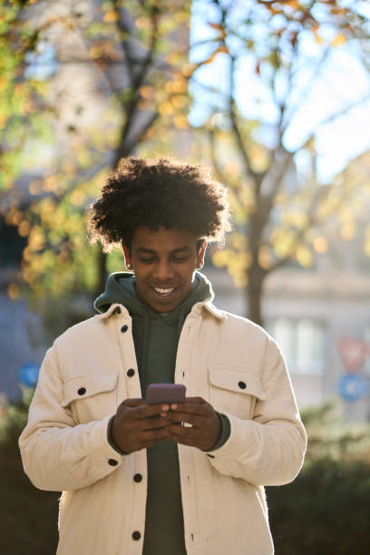 istock Generation z happy African American guy using mobile phone outdoors. 1471727273