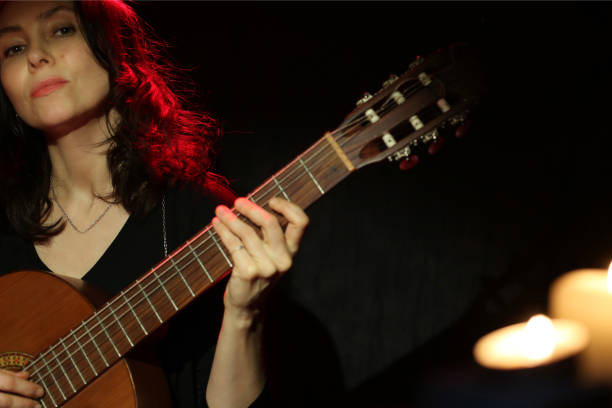 istock Romantic woman playing guitar isolated on black background 1471728029