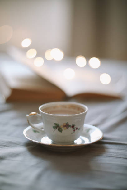 istock Light cozy bedroom, Coffee or tea cup and an open book on the bed. Spring still life. Breakfast in bed. 1471732504