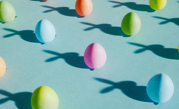 istock Trendy pattern made of colorful easter eggs with funny rabbit shadow on pastel blue cardboard. Spring concept for design templates or greeting card. 1471733226