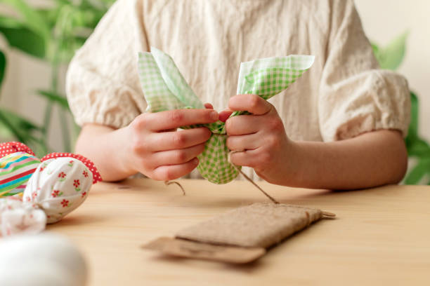 istock Making Easter decorations. Close-up of a girl's hands making textile easter egg a shape of bunny, rabbit 1471733671