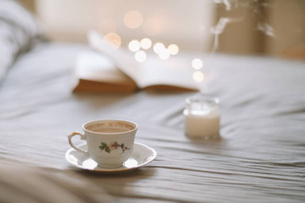 istock Light cozy bedroom, Coffee or tea cup and an open book on the bed. Spring still life. Breakfast in bed. 1471733778
