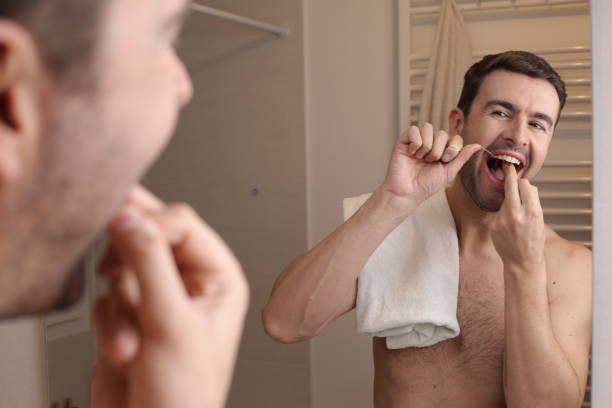 istock Man flossing in the mirror 1471733810