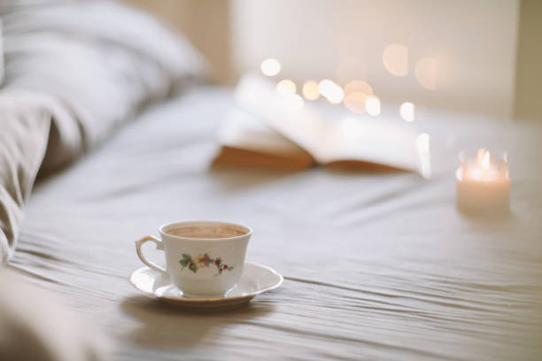istock Light cozy bedroom, Coffee or tea cup and an open book on the bed. Spring still life. Breakfast in bed. 1471733833