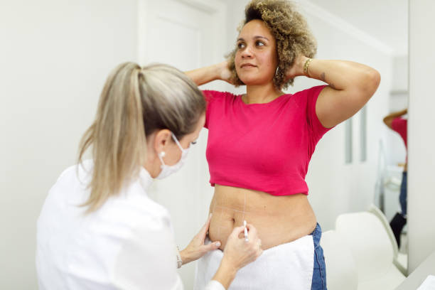 Beautician marking client's body before a cosmetic procedure