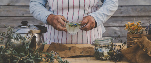 istock Grandmother makes tea with medicinal herbs. Selective focus. 1471735394