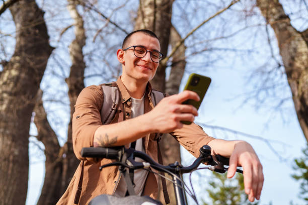 istock Young man using mobile phone with his bike, outdoors. 1471739051