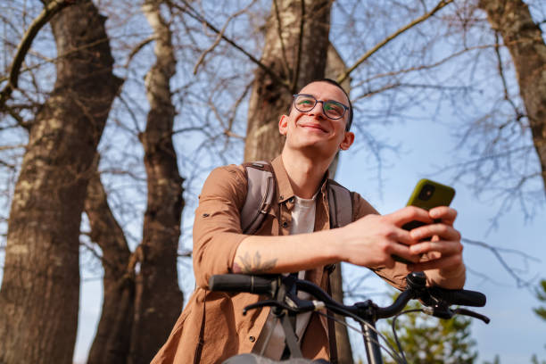 istock Young man using mobile phone with his bike, outdoors. 1471739052