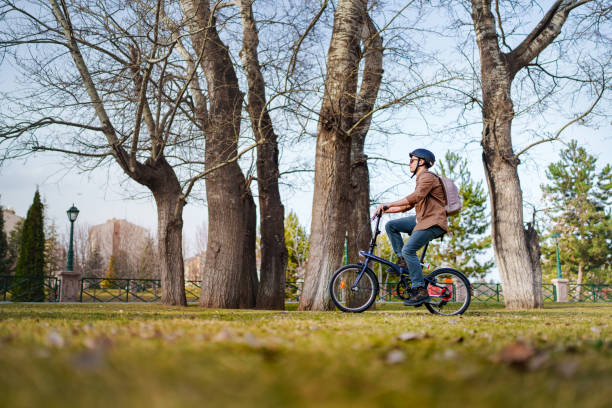 istock Man wearing helmet, riding bicycle in park. 1471739513
