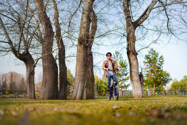 istock Man wearing helmet, riding bicycle in park. 1471739783