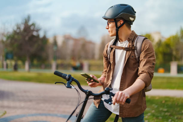 istock Young man using mobile phone with his bike, outdoors. 1471741640