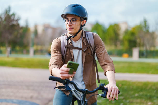 istock Young man using mobile phone with his bike, outdoors. 1471741642
