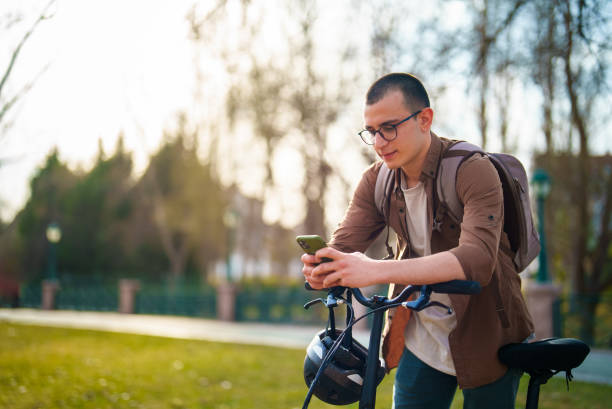 istock Young man using mobile phone with his bike, outdoors. 1471741669