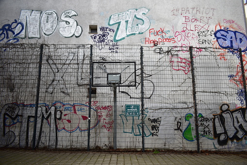 Berlin, Germany - 03 02 2023: Street basketball court with street art on the building behind