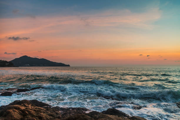 Beautiful sunset on the rock beach. Phuket, Thailand