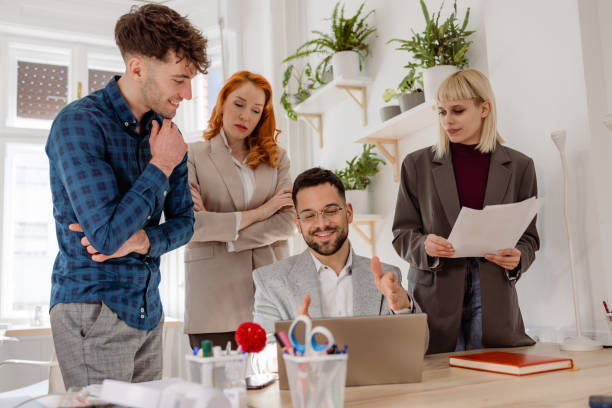 istock A smiling man is discussing a project with coworkers 1471749544