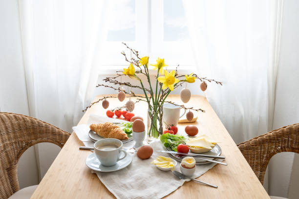 istock Breakfast for two with daffodils and Easter decoration on a wooden table at the window, copy space, selected focus 1471751858