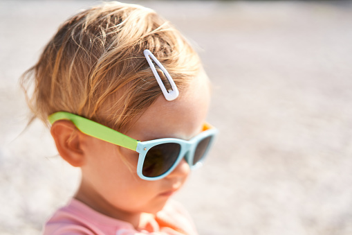 Little girl in sunglasses with a hairpin on her head. Portrait. High quality photo