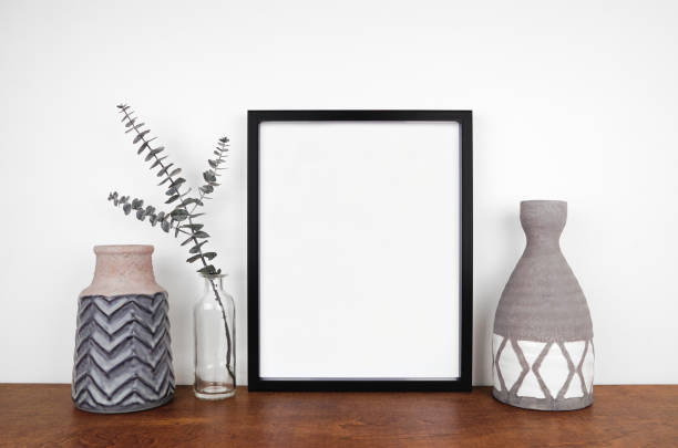 istock Mock up black frame with clay vases and eucalyptus branch on a wood shelf 1471753288
