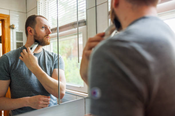 istock In a modern bathroom, a Caucasian White man trims his beard using a cordless trimmer. 1471757084