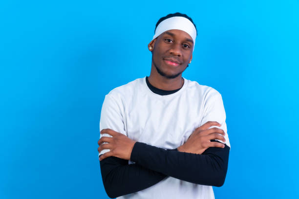 istock Black ethnic man in white clothes on a blue background, arms crossed 1471759901