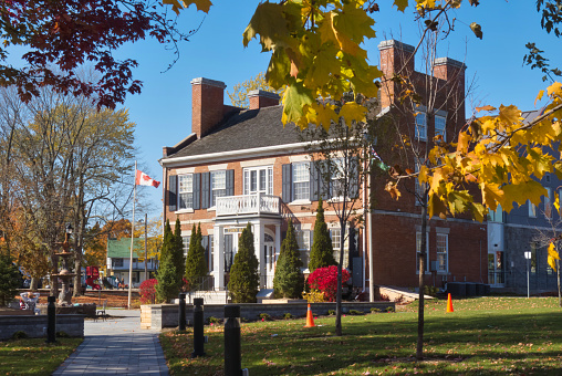 gananoque, canada - 22 October 2022 : a town hall or city hall based in a historic mansion with small park or gardens