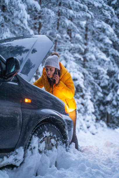 istock Winter car breakdown, woman calls for help. 1471761866