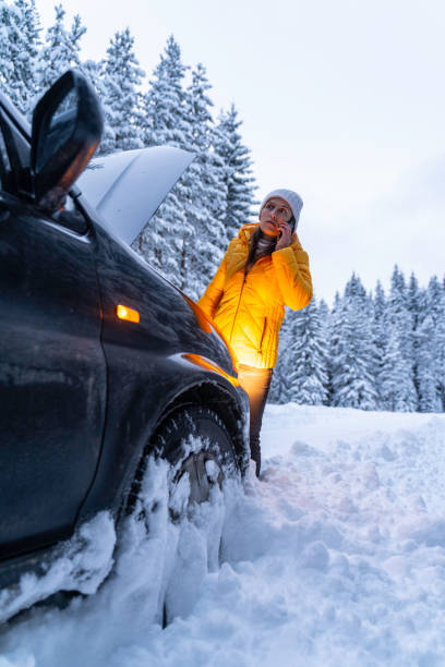 istock Winter car breakdown, woman calls for help. 1471761879