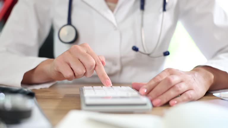 Practitioner using calculator in clinic calculating health insurance